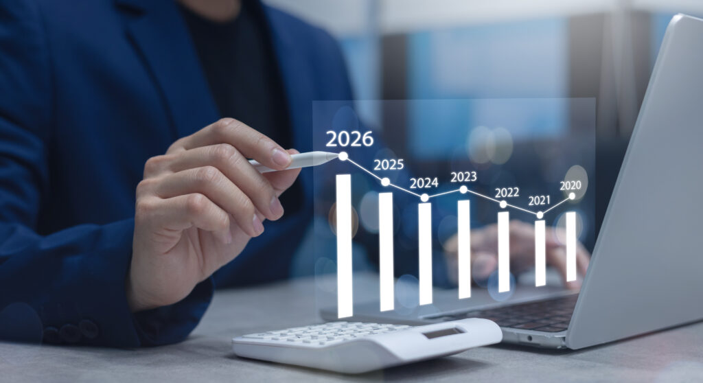 Business owner reviewing 2026 annual report fee changes by state on a laptop with compliance documents and notes on desk