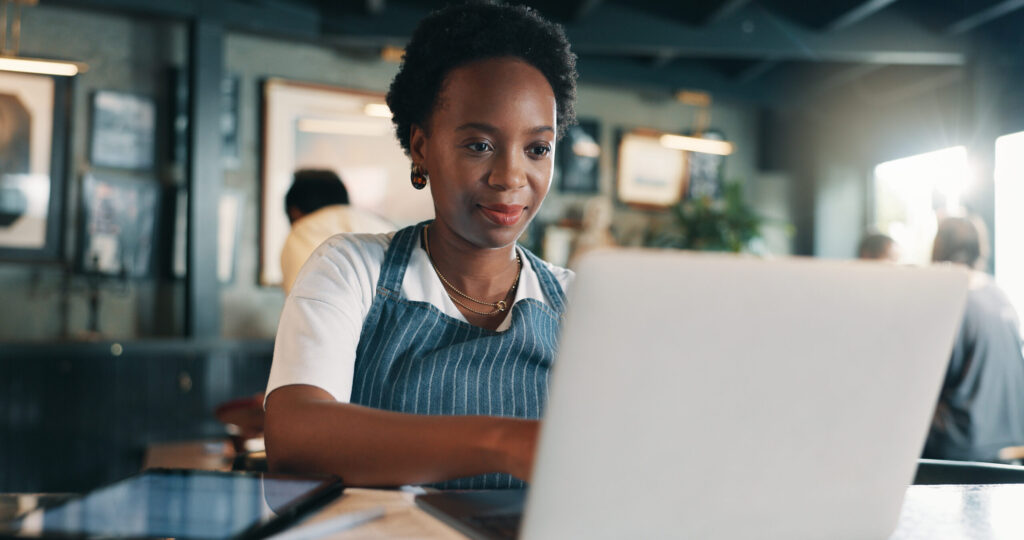 A Wisconsin small business owner sits at a desk with a laptop, a filing checklist, and a calendar showing a highlighted deadline, symbolizing preparation for an annual report filing.